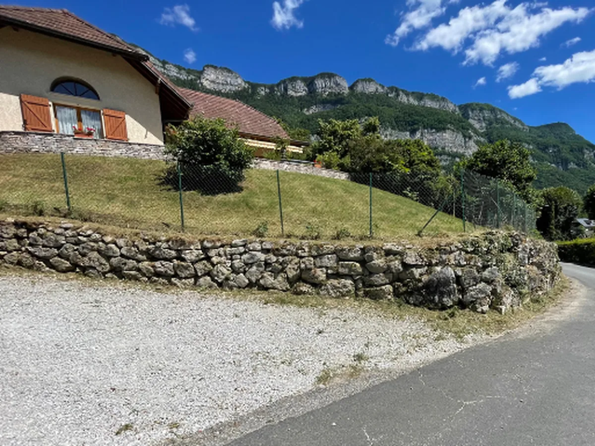 Talus débroussaillé et muret en pierre désherbé, à Drumettaz-Clarafond.